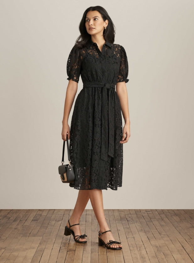 model wearing black lace midi dress with black sandals holding bag